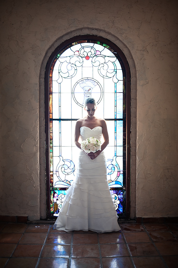 portrait of bride standing in front of stained glass window - photo by Houston based wedding photographer Adam Nyholt